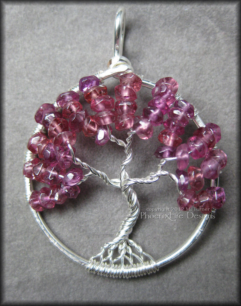 Stunning, semi-precious Rhodolite Garnet rondelles in a bright raspberry pink color are set in sterling silver wire to form a beautiful Tree of Life pendant. 
