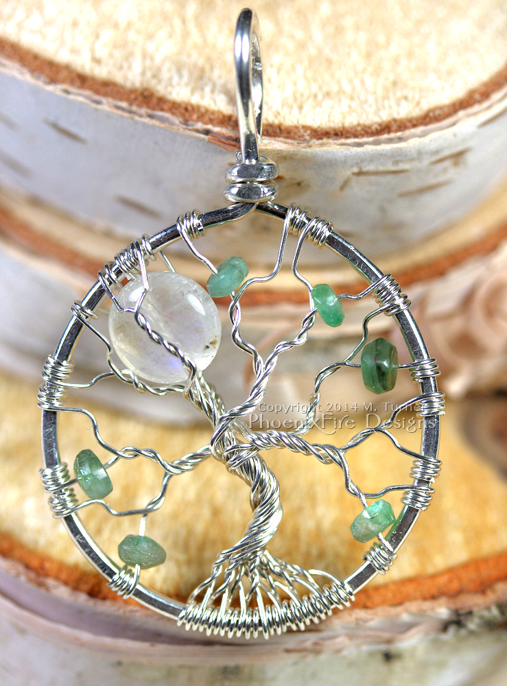 Custom rainbow moonstone full moon tree of life with scattering of emeralds.